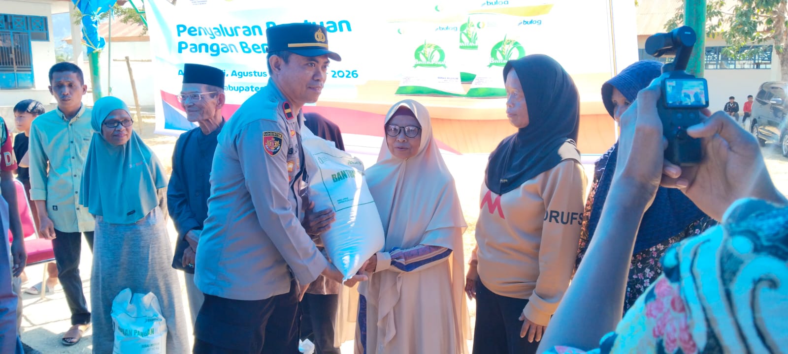 Kapolsek Tutar Hadiri Penyaluran Bantuan Pangan Beras Bulog di Desa Ambopadang